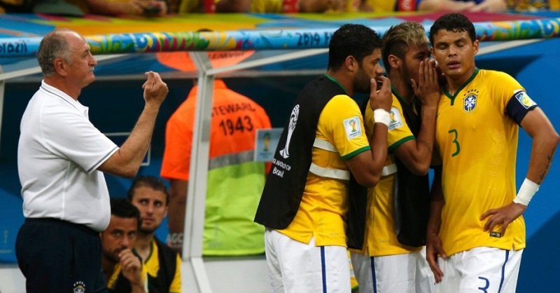 Troca de comando técnico no jogo contra a Holanda: os jogadores do banco passando instruções para Thiago Silva, com Felipão esquecido à esquerda. Retrato de um time para se esquecer.